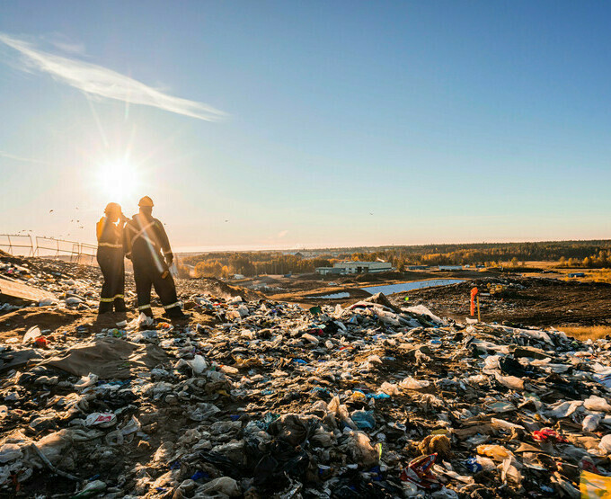 2 workers are standing on top of landfill